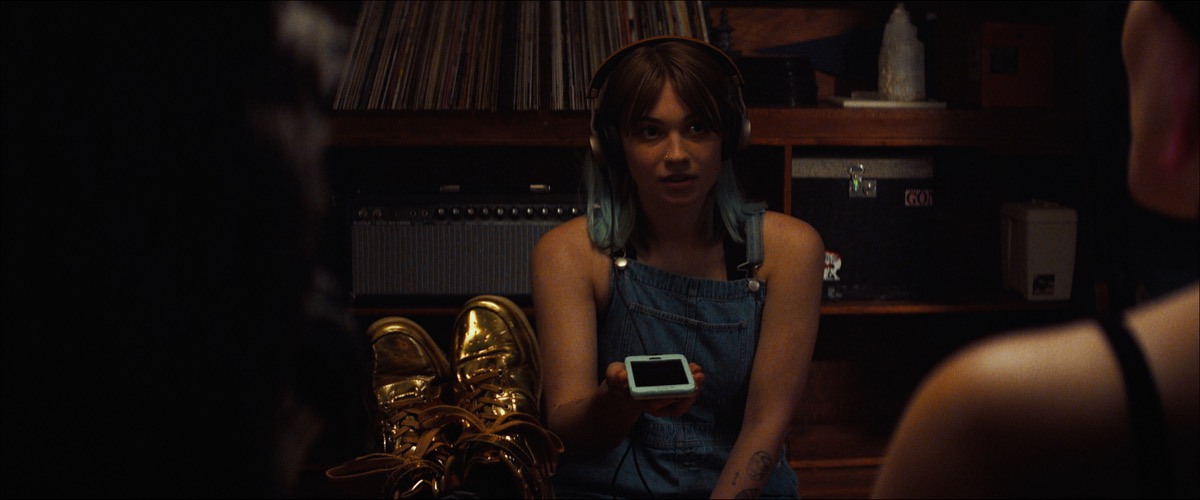 Lennon spends much of the film recording podcast interviews on her phone (image provided by Oscilloscope)